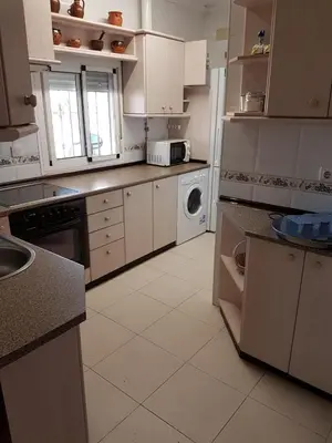 a kitchen with white cabinets and a white appliance at El Cotín Rural House in Novo Sancti Petri