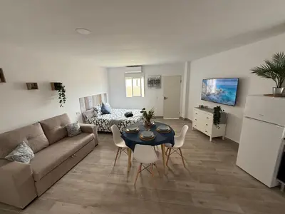 a living room with a couch and a table and chairs at Ático Bf Jerez in Jerez de la Frontera