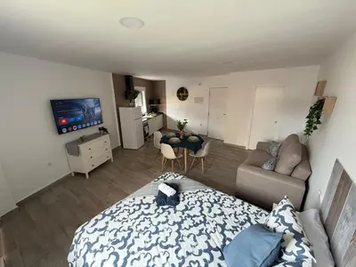 a bedroom with a bed and a living room at Ático Bf Jerez in Jerez de la Frontera