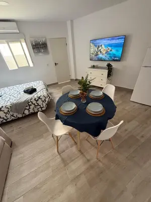 a living room with a table and chairs and a bed at Ático Bf Jerez in Jerez de la Frontera