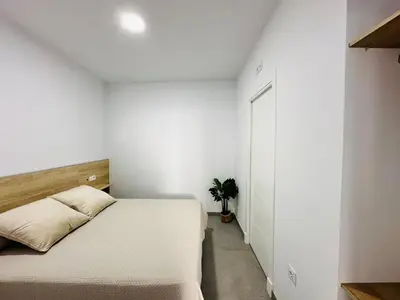 a white bedroom with a bed and a closet at Pradera Villa Encanto in Chiclana de la Frontera
