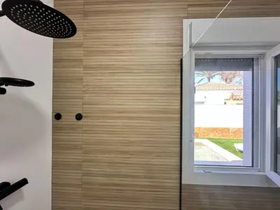 a shower with a glass door and a window at Pradera Villa Encanto in Chiclana de la Frontera