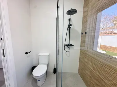 a bathroom with a toilet and a shower at Pradera Villa Encanto in Chiclana de la Frontera