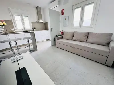 a living room with a couch and a kitchen at Pradera Villa Encanto in Chiclana de la Frontera