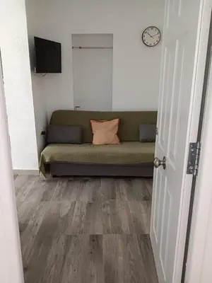 a couch in a room with a clock on the wall at Plateros 4 in Jerez de la Frontera