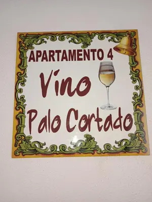a sign with a glass of wine on a wall at Plateros 4 in Jerez de la Frontera