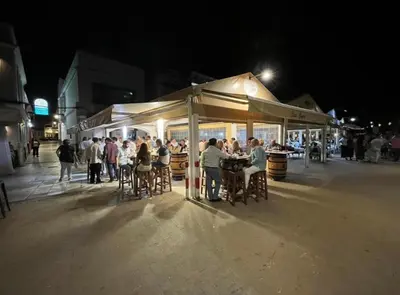 a group of people sitting at tables in a street at night at Mirador de Sanlucar 3 in Sanlúcar de Barrameda