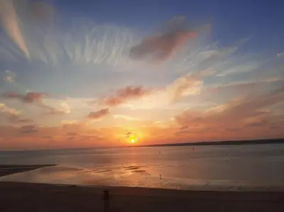 a sunset on the beach with the sun setting at Mirador de Sanlucar 3 in Sanlúcar de Barrameda