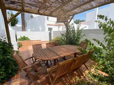 a wooden table and chairs on a patio at Duplex Las Torres La Barrosa - 750m from the Beach in Novo Sancti Petri