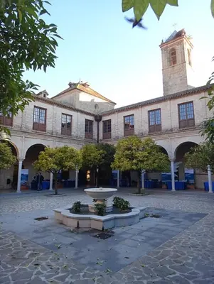 a building with a fountain in the middle of a courtyard at El Patio de María 2 in Bornos