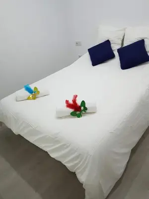 a white bed with three pillows on it at Playa La Caleta in Cádiz