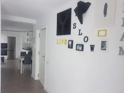 a room with a white wall with pictures on it at Playa La Caleta in Cádiz