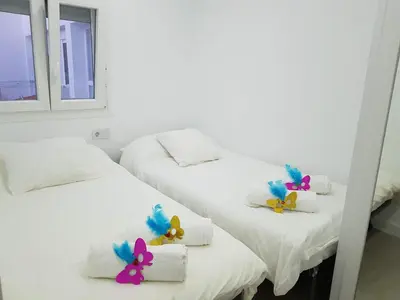 two beds with flowers on them in a room at Playa La Caleta in Cádiz