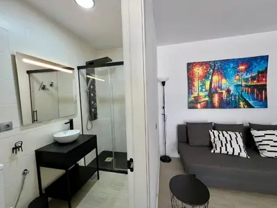 a bathroom with a couch and a sink in a room at El Refugio in Chiclana de la Frontera
