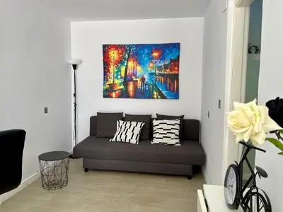 a living room with a couch and a painting on the wall at El Refugio in Chiclana de la Frontera