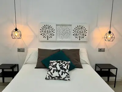 a bedroom with a white bed with two night stands at El Refugio in Chiclana de la Frontera