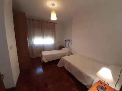 a room with two beds and a table and a lamp at Casa Toya in Arcos de la Frontera