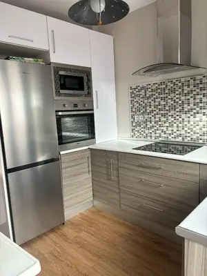 a kitchen with white cabinets and stainless steel appliances at La Barrosita in Chiclana de la Frontera