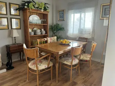 a dining room table and chairs with a bowl of fruit on it at La Barrosita in Chiclana de la Frontera