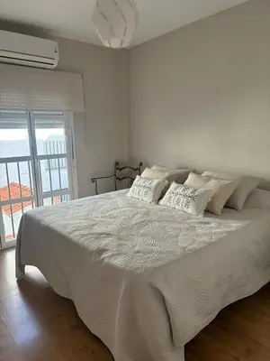 a bedroom with a large bed with white sheets and pillows at La Barrosita in Chiclana de la Frontera