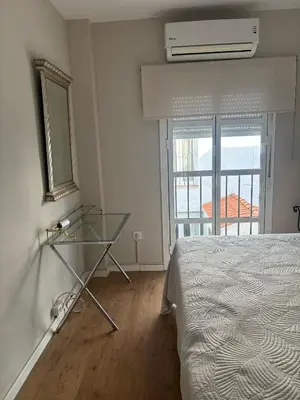 a bedroom with a bed and a mirror and a window at La Barrosita in Chiclana de la Frontera