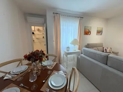 a living room with a table and a couch at Malandar Playa in Sanlúcar de Barrameda