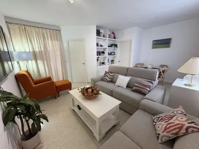 a living room with a couch and a table at Malandar Playa in Sanlúcar de Barrameda