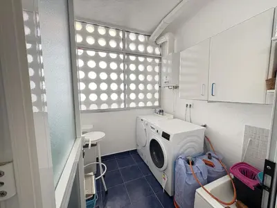 a laundry room with a washing machine and a window at Malandar Playa in Sanlúcar de Barrameda