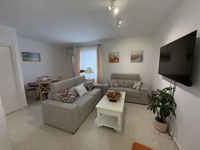 a living room with a couch and a tv at Malandar Playa in Sanlúcar de Barrameda