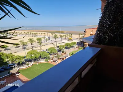 a view of a park from a balcony of a building at Malandar Playa in Sanlúcar de Barrameda