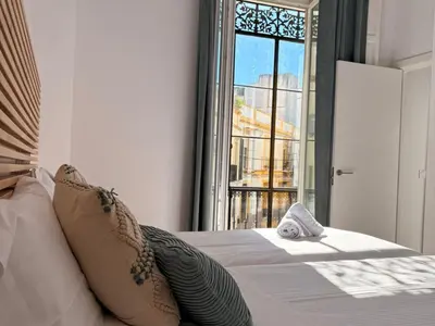 a bedroom with a bed with a large window at Life Apartments Arcos 27 in Jerez de la Frontera