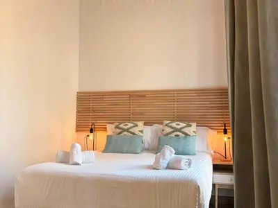 a bedroom with a large white bed with blue pillows at Life Apartments Arcos 27 in Jerez de la Frontera