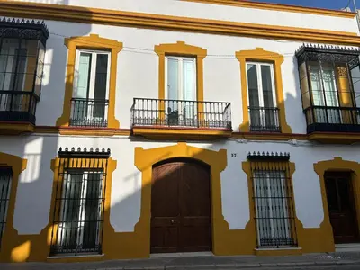 a yellow and white building with windows and a door at Life Apartments Arcos 27 in Jerez de la Frontera