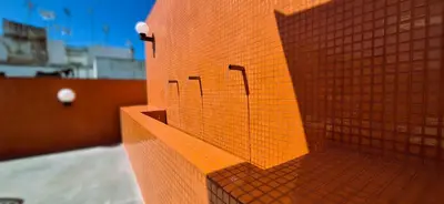 a orange brick wall with three stalls on it at Apartamentos Robles 4 by Gades Gestión in Cádiz