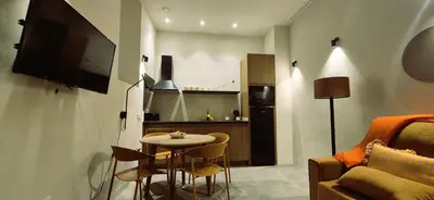 a living room with a small table and a tv at Apartamentos Robles 4 by Gades Gestión in Cádiz