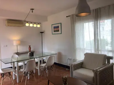 a living room with a glass table and chairs at Casa Hortensia in Chiclana de la Frontera