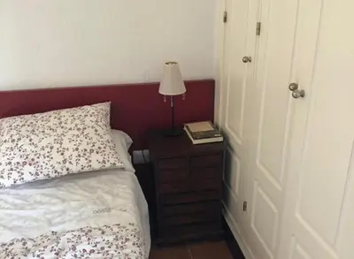 a bedroom with a bed and a lamp on a night stand at Casa Hortensia in Chiclana de la Frontera
