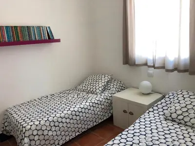 two twin beds in a room with at Casa Hortensia in Chiclana de la Frontera
