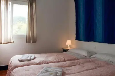 two beds sitting in a room with a window at Casa Hortensia in Chiclana de la Frontera