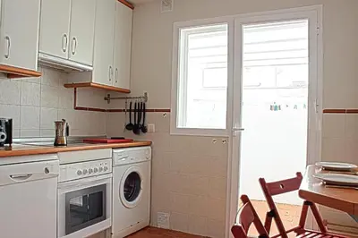 a kitchen with a washing machine and a window at Casa Hortensia in Chiclana de la Frontera