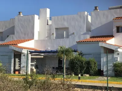a building with a fence in front of it at Casa Hortensia in Chiclana de la Frontera