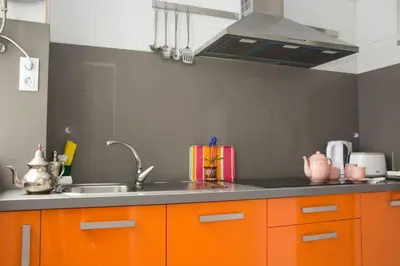 a kitchen with orange cabinets and a sink at Apartamento Cádiz Centro Histórico in Cádiz
