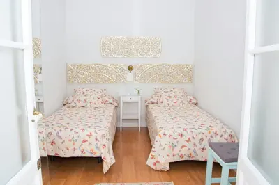 a bedroom with two beds and a desk and a window at Apartamento Cádiz Centro Histórico in Cádiz