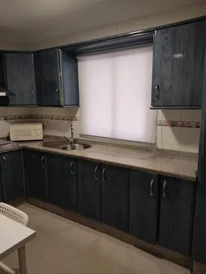 a kitchen with dark blue cabinets and a sink at Apartamento Plaiya De La Red in Sanlúcar de Barrameda