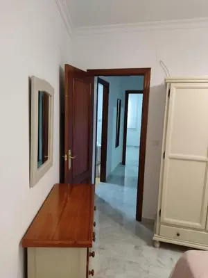 a hallway with a dresser and a mirror on a wall at Apartamento Plaiya De La Red in Sanlúcar de Barrameda