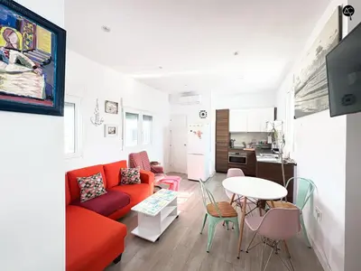 a living room with a red couch and a table at Penthouse Libertad Grupo AC Gestion in Cádiz