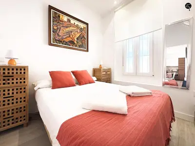 a bedroom with a white bed with a red blanket at Penthouse Libertad Grupo AC Gestion in Cádiz