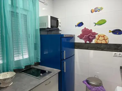 a kitchen with a sink and a blue refrigerator at Apartamento Pacífico in Chipiona