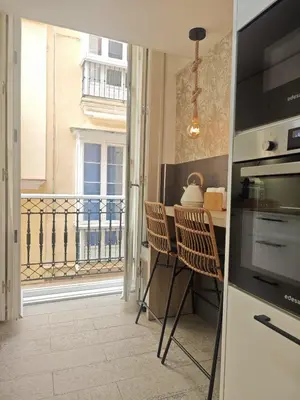 a kitchen with a table and chairs and a balcony at El Rincón de Ro Little Apartments in Cádiz