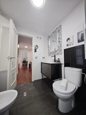a bathroom with a toilet and a sink and a mirror at El Rincón de Ro Little Apartments in Cádiz